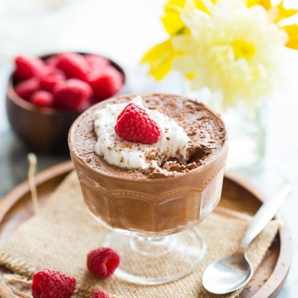 Aquafaba Chocolate Mousse topped with coconut whipped cream and raspberries