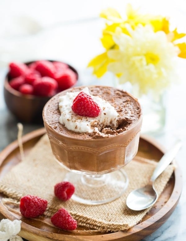 Aquafaba Chocolate Mousse topped with coconut whipped cream and raspberries