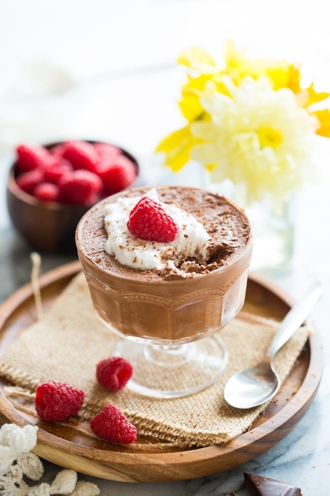 Aquafaba Chocolate Mousse topped with coconut whipped cream and raspberries