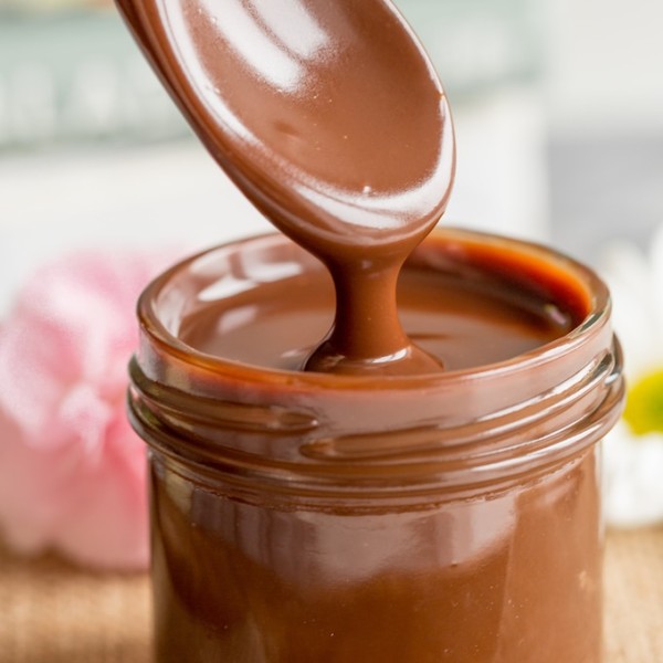 Dairy Free Chocolate Fudge Sauce in a small jar dripping from a spoon