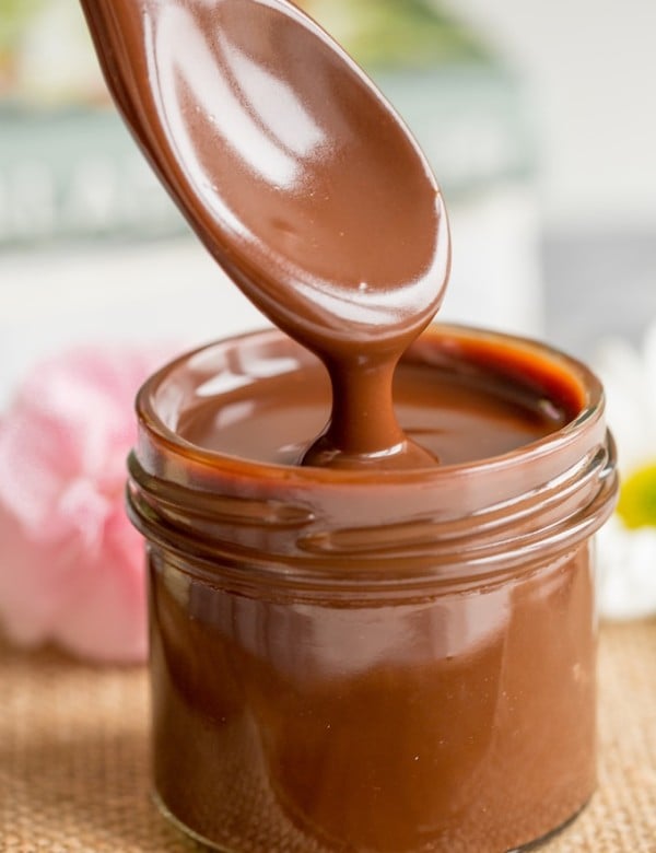 Dairy Free Chocolate Fudge Sauce in a small jar dripping from a spoon