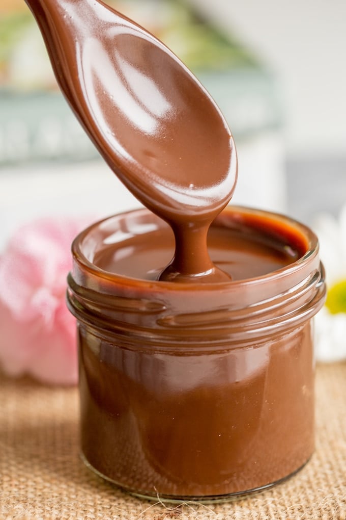 Dairy Free Chocolate Fudge Sauce in a small jar dripping from a spoon