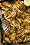 Instant Pot Chicken Carnitas shredded on a baking sheet with forks