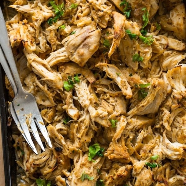 Instant Pot Chicken Carnitas shredded on a baking sheet with forks
