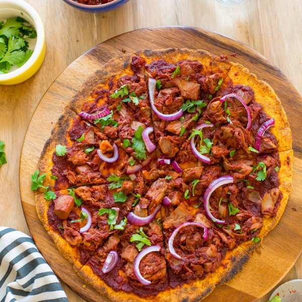 sliced Jackfruit BBQ Pizza with a Sweet Potato Crust on a serving tray and topped with fresh cilantro