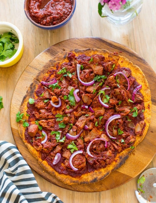 sliced Jackfruit BBQ Pizza with a Sweet Potato Crust on a serving tray and topped with fresh cilantro