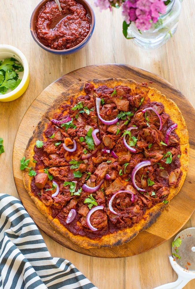 sliced Jackfruit BBQ Pizza with a Sweet Potato Crust on a serving tray and topped with fresh cilantro