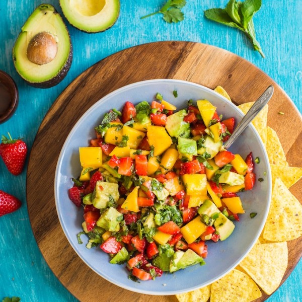 Spicy Avocado Strawberry Mango Salsa in a serving bowl with chips on a plate