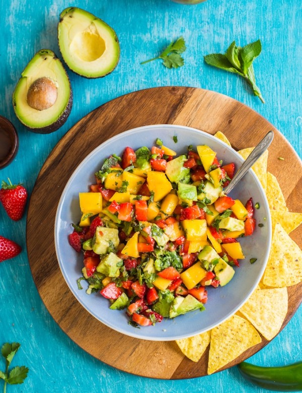 Spicy Avocado Strawberry Mango Salsa in a serving bowl with chips on a plate