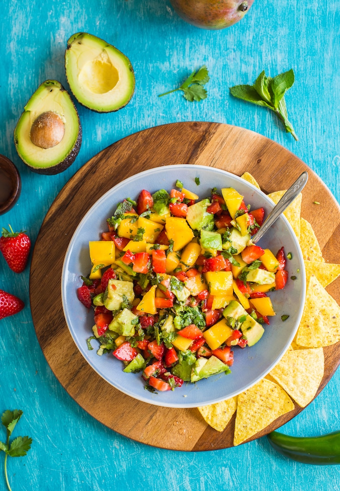 Spicy Avocado Strawberry Mango Salsa in a serving bowl with chips on a plate