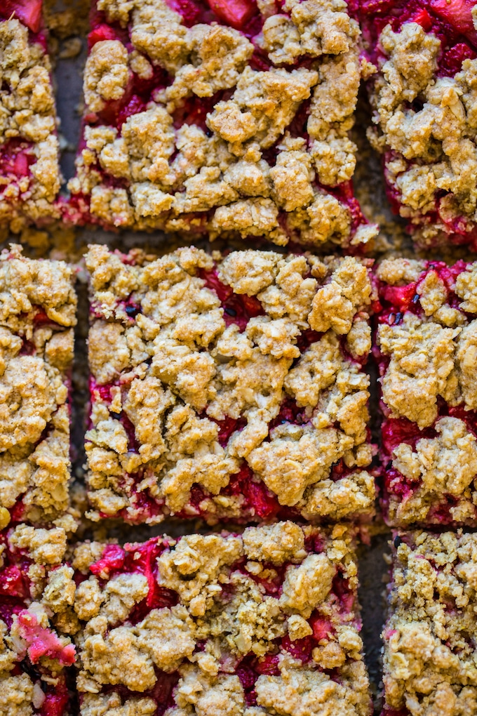 Strawberry Crumb Bars cut into squares closely arranged on baking paper