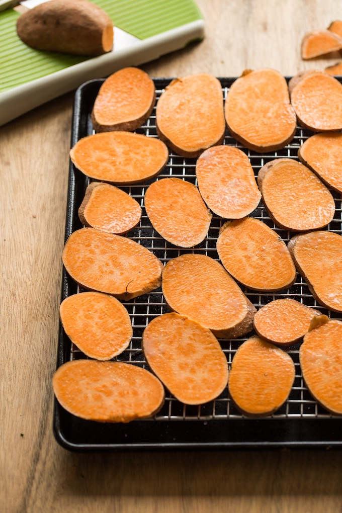 sweet potatoes sliced on a baking sheet before baking