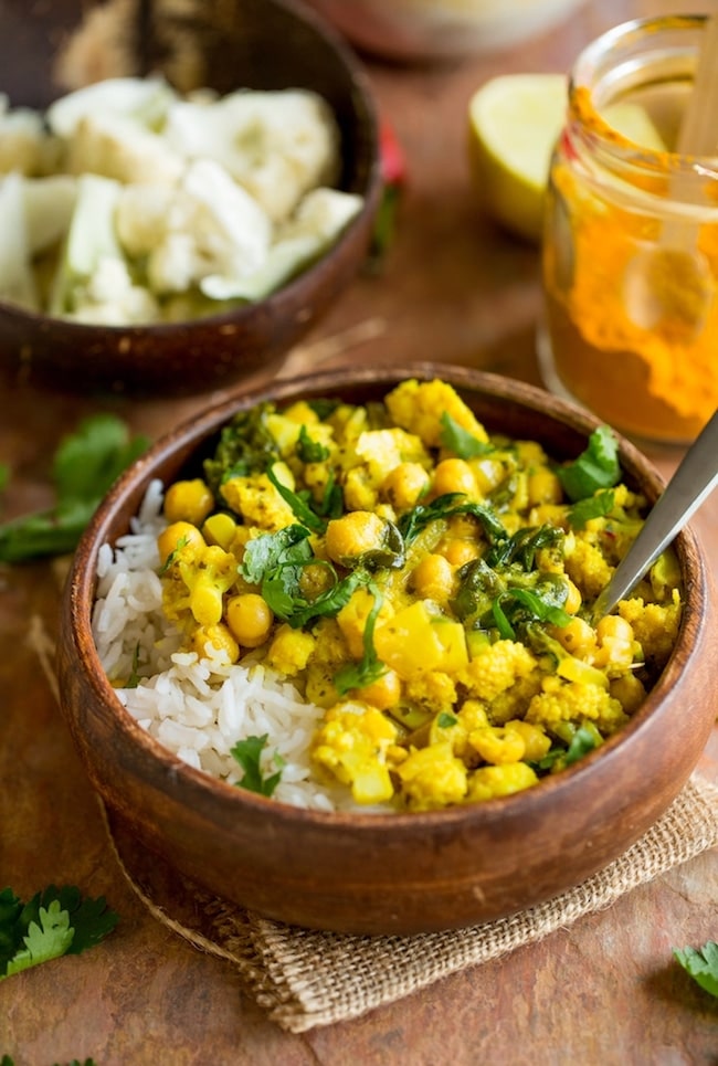 yellow cauliflower curry in a bowl over rice 