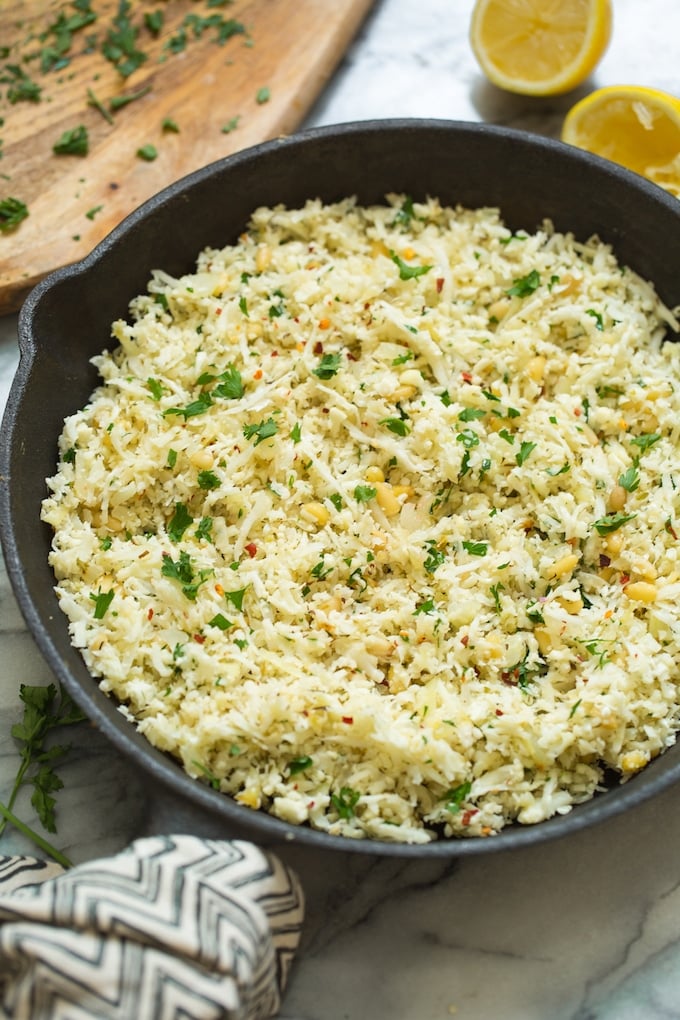 Mediterranean Cauliflower Rice in a cast iron skillet on a marble surface