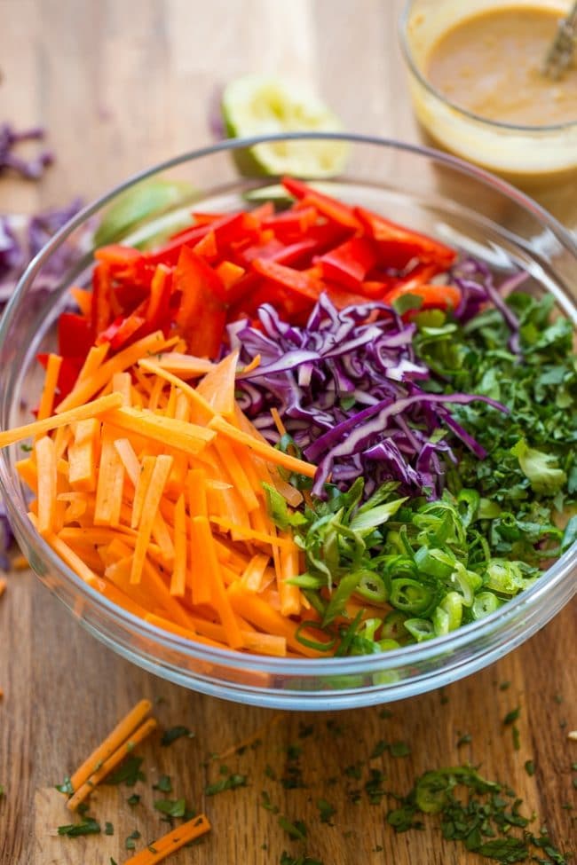 Thai Peanut Coleslaw ingredients: carrot, cabbage, red pepper, spring onions and cilantro in a bowl