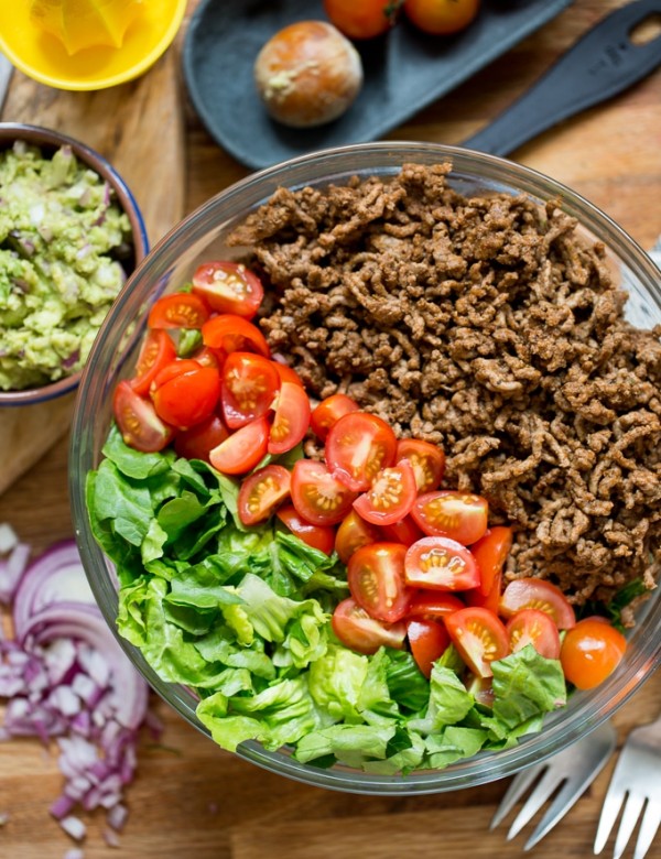 Whole30 Taco Salad: ground beef, chopped tomatoes and lettuce in a salad bowl with guacamole on the side