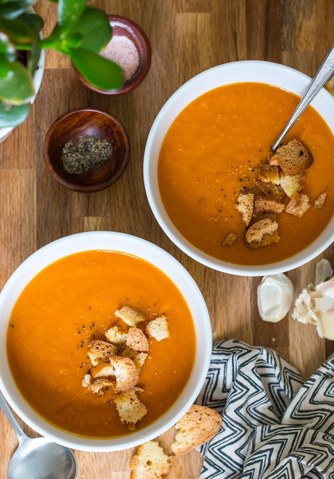 two bowls of easy tomato soup topped with croutons and black pepper