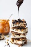vegan snickers cheesecake stack with chocolate drizzling over the top