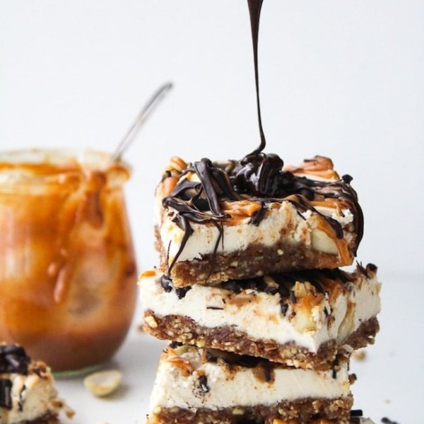 vegan snickers cheesecake stack with chocolate drizzling over the top