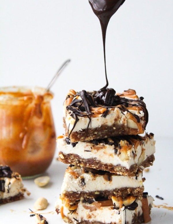 vegan snickers cheesecake stack with chocolate drizzling over the top