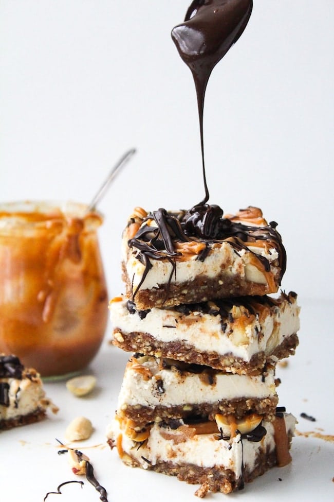 vegan snickers cheesecake stack with chocolate drizzling over the top