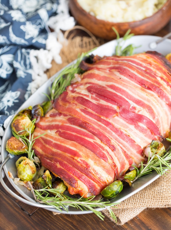 Roasted Turkey Roulade & Fig Sausage Stuffing on a serving plate with brussels sprouts and rosemary