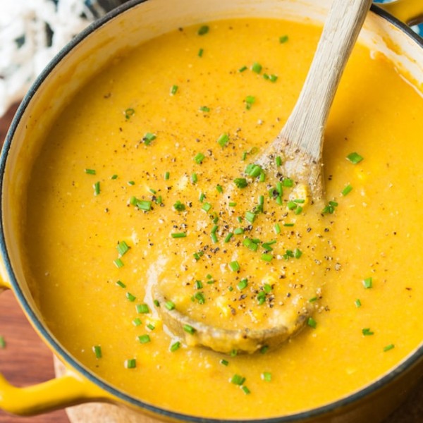 vegan corn chowder in a soup pot with a ladle