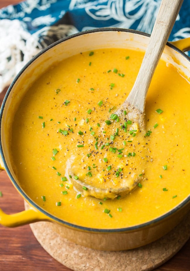 vegan corn chowder in a soup pot with a ladle 