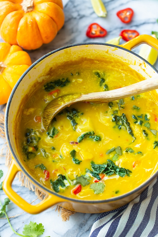 thai pumpkin soup in a soup pot with a ladle 