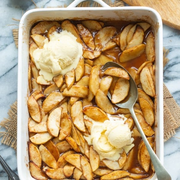 Baked Cinnamon Apples in a baking dish topped with ice cream