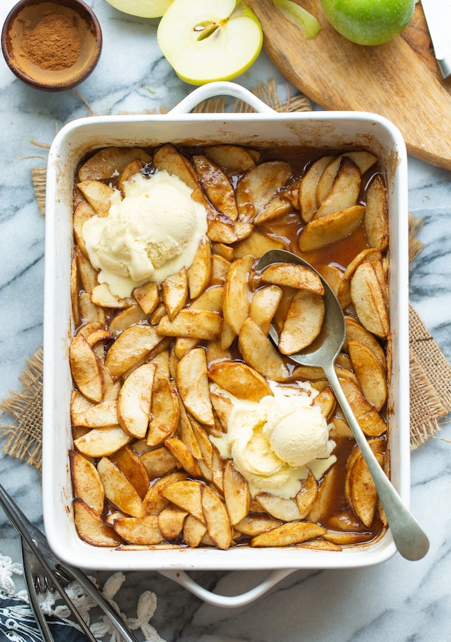 Baked Cinnamon Apples in a baking dish topped with ice cream