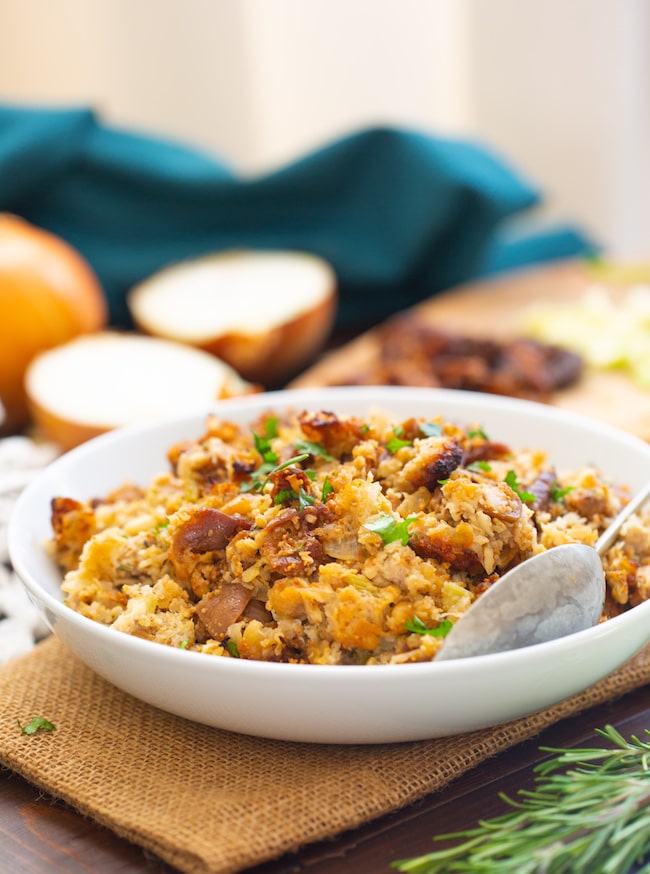 Fig & Sausage Cauliflower Stuffing in a serving bowl with a spoon