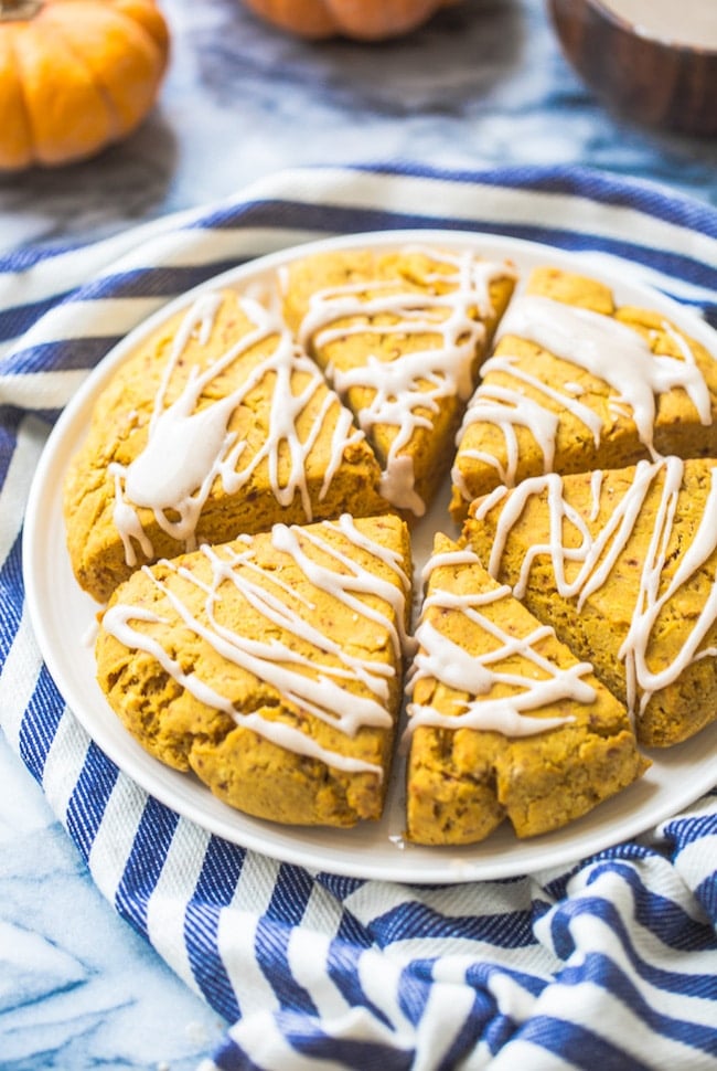 Gluten Free Vegan Pumpkin Scones on a plate on a blue and white striped kitchen towel