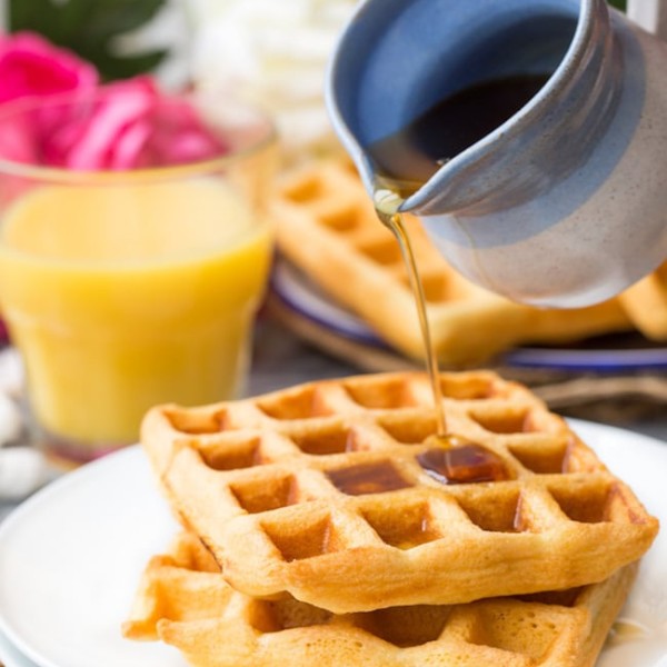 Gluten Free Waffles on a plate with maple syrup pouring over the top