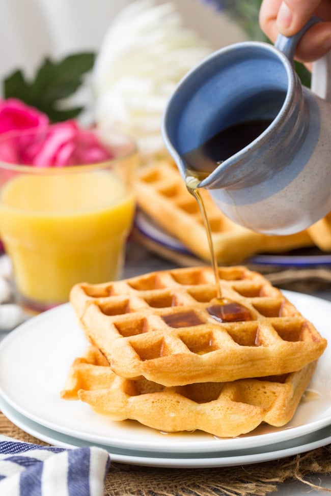Gluten Free Waffles on a plate with maple syrup pouring over the top