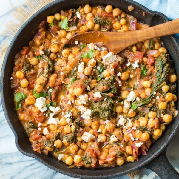 Mediterranean Chickpea Stew with Spinach & Feta in a cast iron skillet on a marble counter