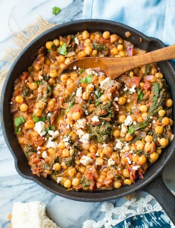 Mediterranean Chickpea Stew with Spinach & Feta in a cast iron skillet on a marble counter