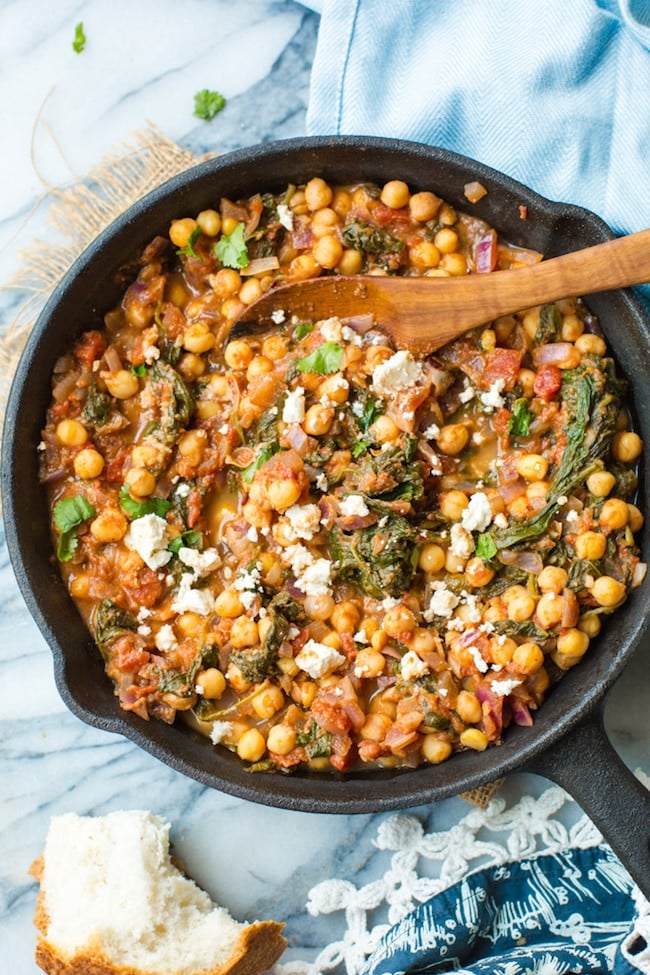 Mediterranean Chickpea Stew with Spinach & Feta in a cast iron skillet on a marble counter