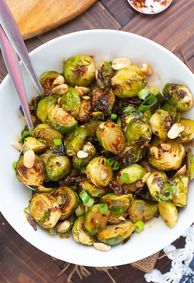 Roasted Teriyaki Brussels Sprouts topped with peanuts and spring onions in a bowl