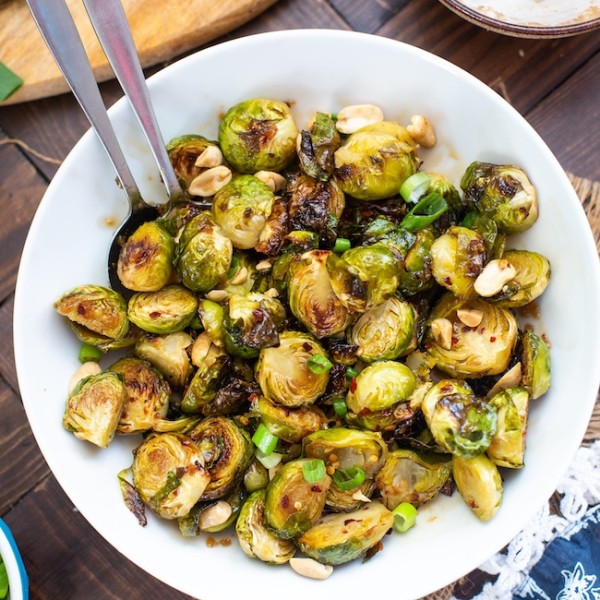 Roasted Teriyaki Brussels Sprouts in a bowl topped with peanuts and green onions