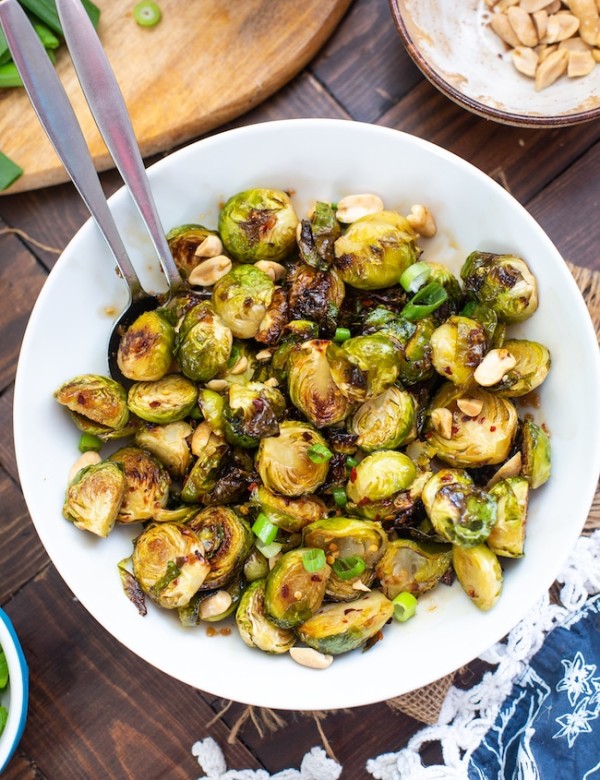 Roasted Teriyaki Brussels Sprouts in a bowl topped with peanuts and green onions