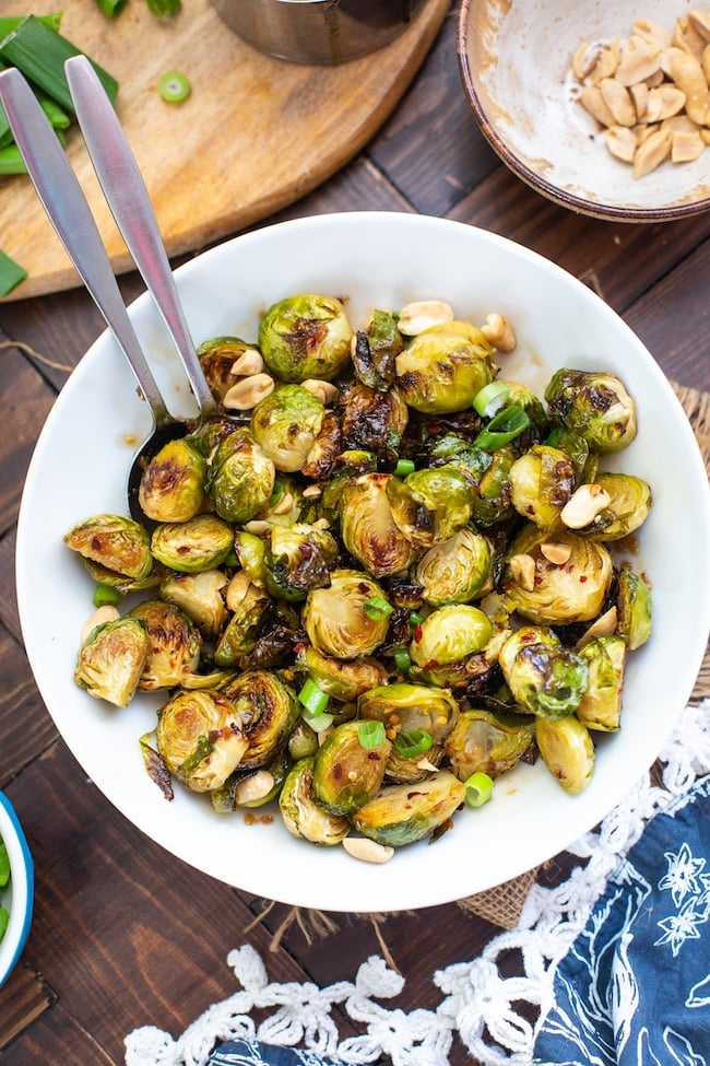 Roasted Teriyaki Brussels Sprouts in a bowl topped with peanuts and green onions