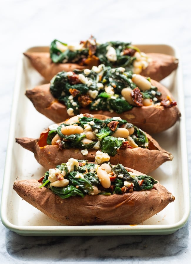 4 Spinach and Feta Stuffed Sweet Potatoes in a row on a baking tray