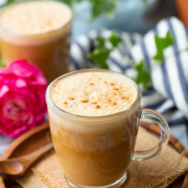 cashew butter latte on a wooden plate sprinkled with cinnamon