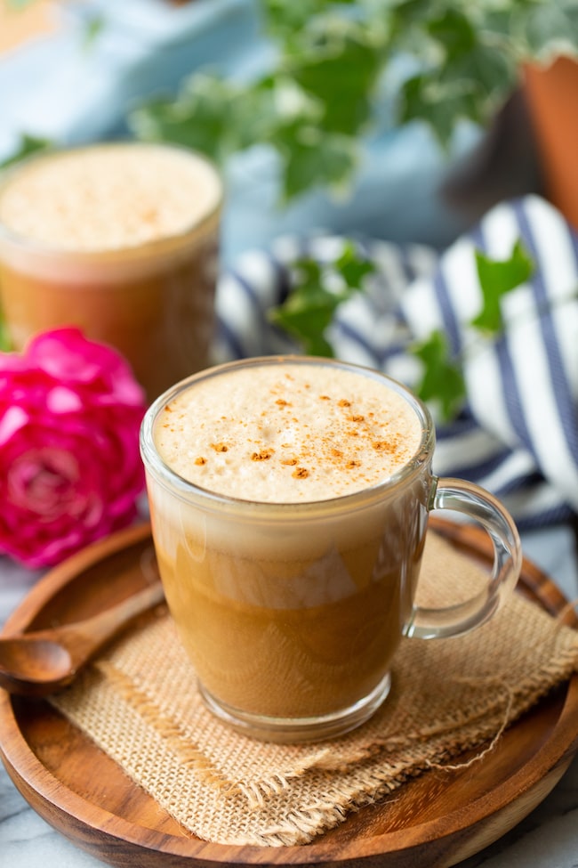 cashew butter latte on a wooden plate sprinkled with cinnamon