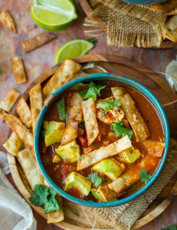 instant pot chicken tortilla soup topped with avocado and cilantro in a green bowl