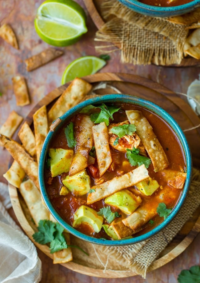 instant pot chicken tortilla soup topped with avocado and cilantro in a green bowl