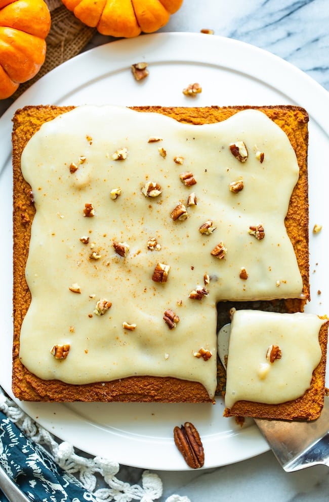 paleo pumpkin cake with a cashew cream frosting topped with chopped pecans