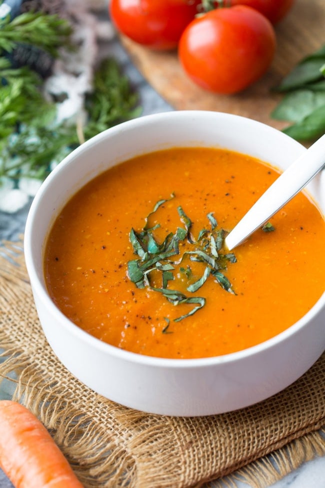 Low FODMAP Carrot Tomato Soup topped with fresh basil up close