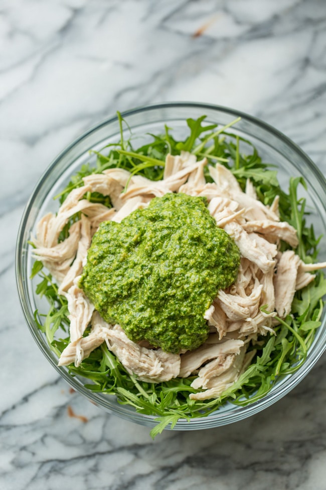 chicken pesto salad in a bowl before it's mixed together